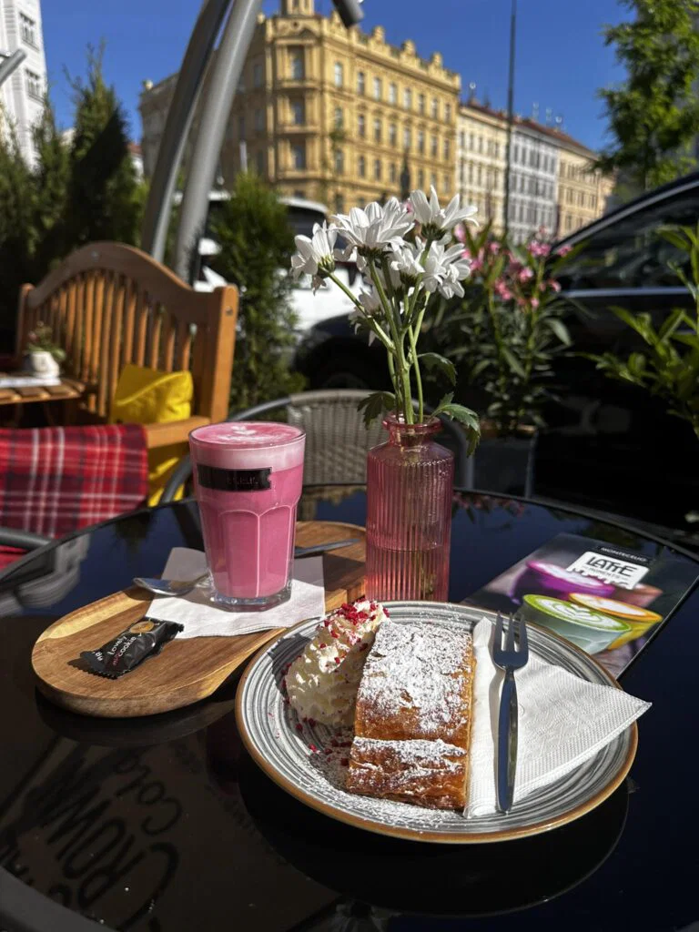 Specialita Růžové latte a domácí jablečný závin se šlehačkou na letní zahrádce kavárny GP Caffé