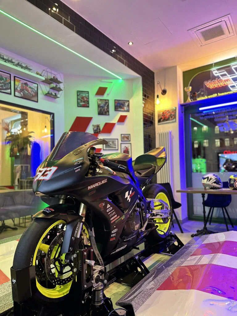 Závodní motorka Marc Márquez 93 v moderním interiéru kavárny GP Caffé